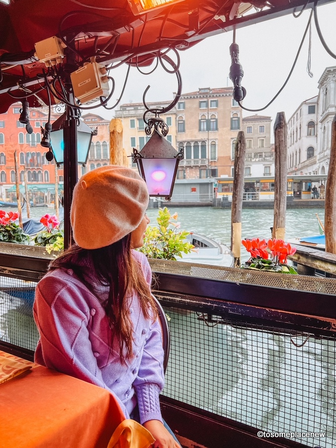 11月，一个女孩在威尼斯的咖啡馆里看着运河