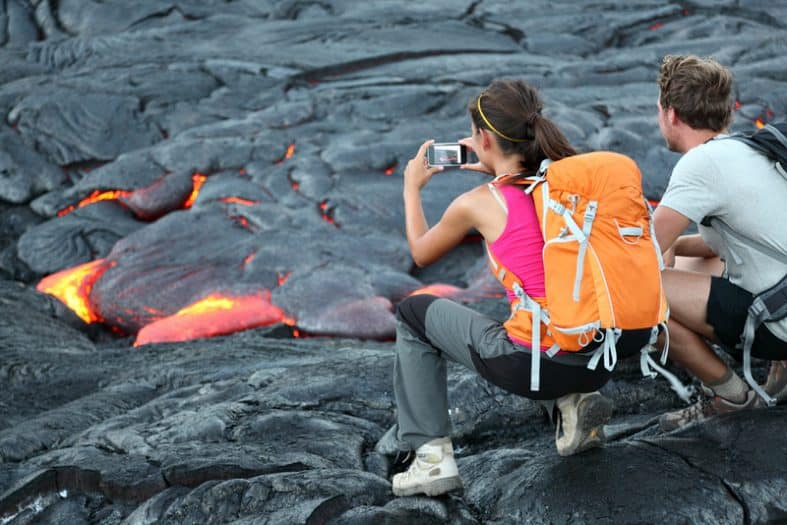 夏威夷熔岩旅游。游客在美国夏威夷火山国家公园附近拍摄基拉韦厄火山流动的熔岩。