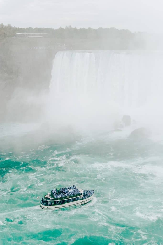 尼亚加拉大瀑布和河上满是人的船在雾中主要的加拿大美国地标