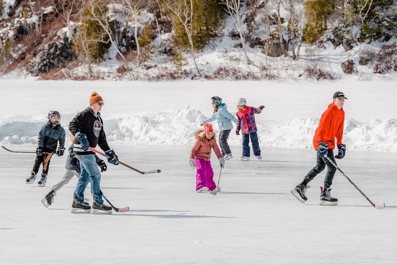 圣约翰- 2019年3月9日:大人和孩子们在冰冻的湖面上练习室外冰球。