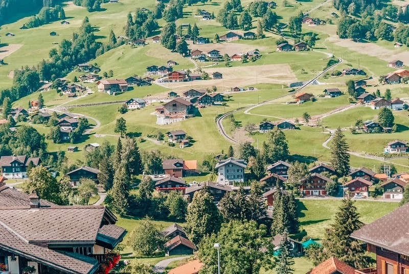 风景如画的瑞士小镇格林德沃。夏天的传统木屋，在艾格尔山北侧被明亮的绿色牧场环绕